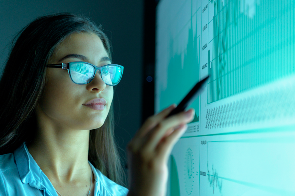 Momentum_Businesswoman_studying_graphs_on_an_interactive_screen_in_business_meeting-low-res.png
