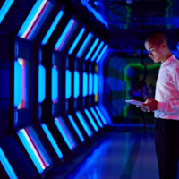 Momentum_Square-200-cyber-data center tunnel-blue-man on tablet-left.png